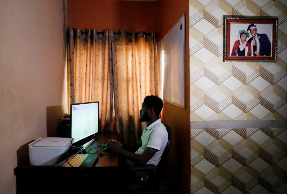 Victor Daniel, 26, a Nigerian coder who created the first African football game, Vikseen Virtual, plays the game in his home in Ogun State, Nigeria, June 23, 2022. REUTERS/Temilade Adelaja