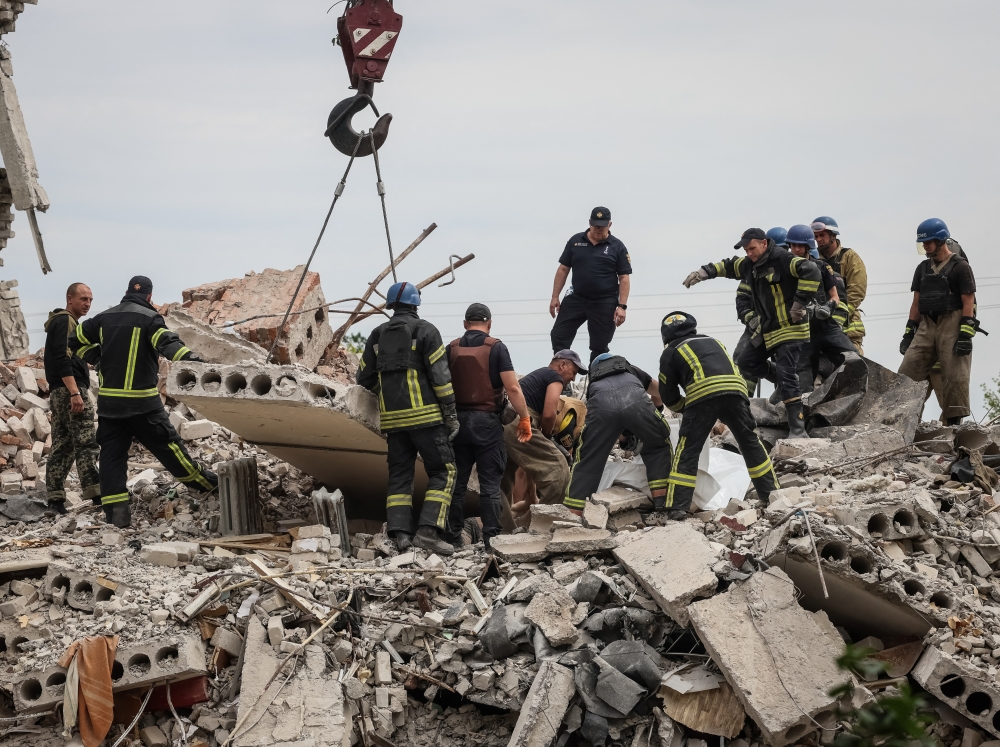 Rescuers extract a body from a residential building damaged by a Russian military strike, amid Russia's invasion of Ukraine, in the town of Chasiv Yar, in Donetsk region, Ukraine July 10, 2022. REUTERS/Gleb Garanich
