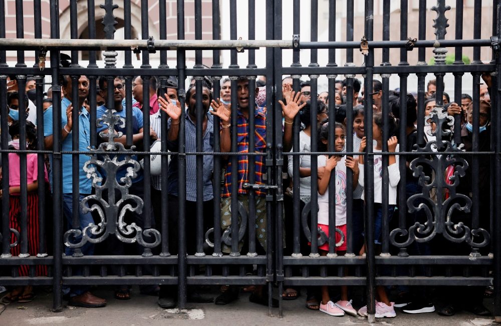 People wait behind a gate to visit the President's house on the day after demonstrators entered the building, after President Gotabaya Rajapaksa fled, amid the country's economic crisis, in Colombo, Sri Lanka July 10, 2022. REUTERS/Dinuka Liyanawatte