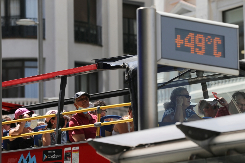 A tourist bus rides past a thermometer displaying 49 Celsius degrees (120.2 Fahrenheit degrees) at Gran Via during the second heatwave of the year in Madrid, Spain, July 15, 2022. (REUTERS/Isabel Infantes)