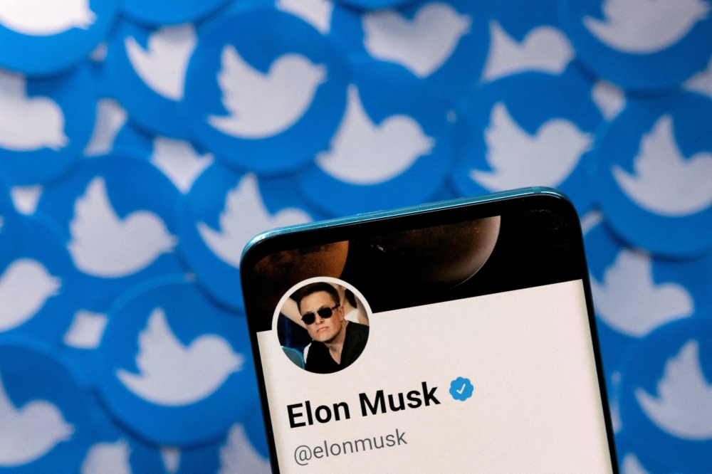 File Photo: Elon Musk's Twitter profile is seen on a smartphone placed on printed Twitter logos in this picture illustration taken April 28, 2022. (REUTERS/Dado Ruvic)