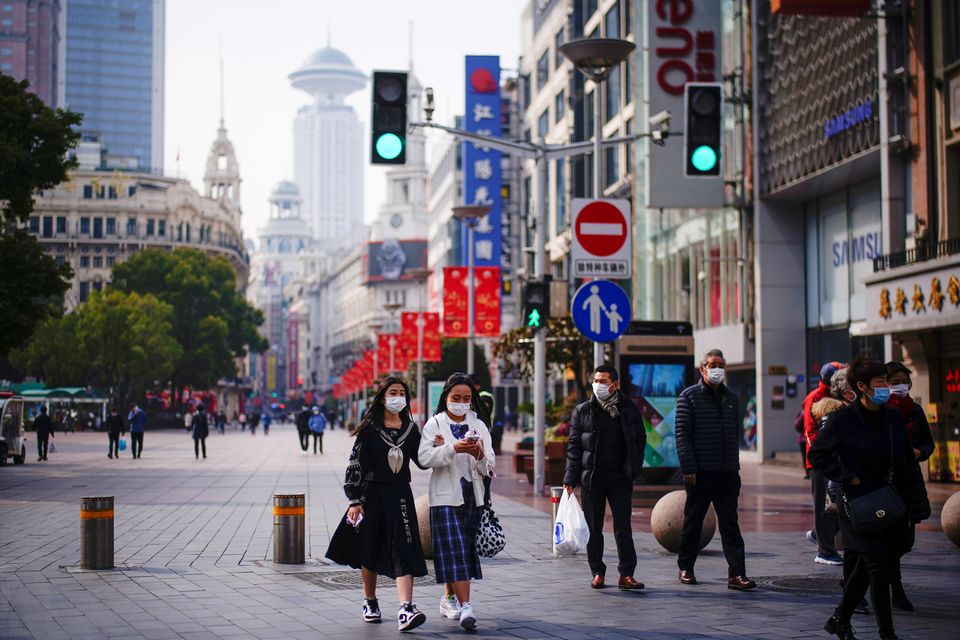 People wearing face masks walk at a main shopping area, following the coronavirus disease (COVID-19) outbreak in Shanghai, China January 27, 2021. REUTERS/Aly Song/File Photo


