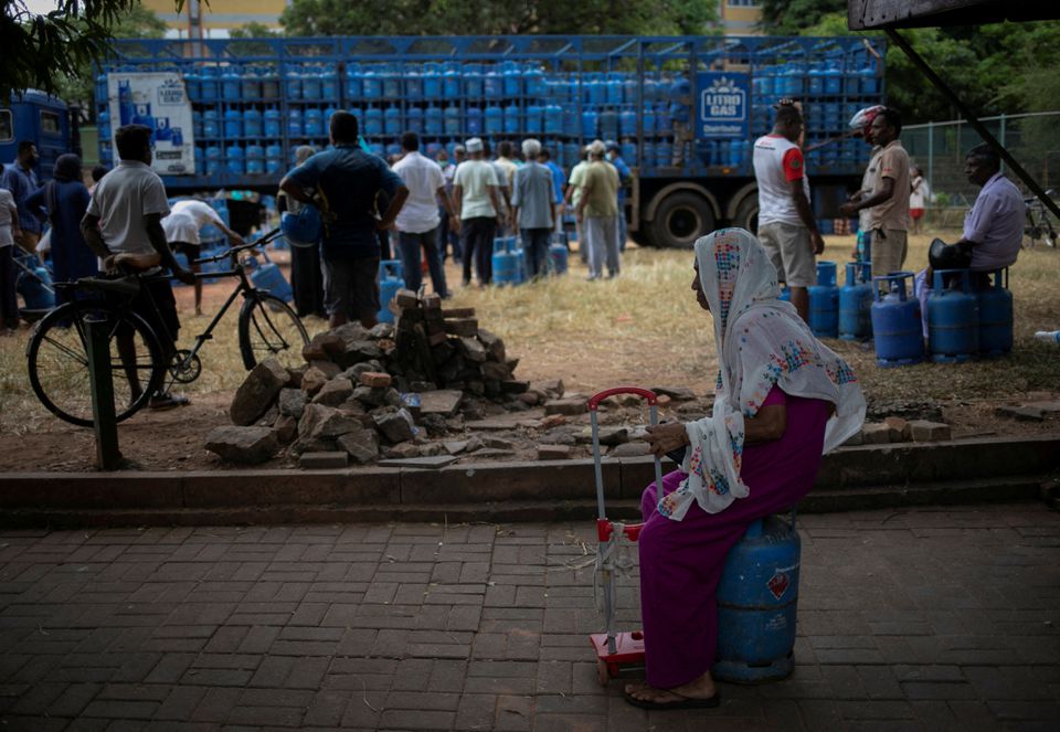 A woman sits on an empty domestic cooking gas cylinder at a distribution centre, amid the country's economic crisis, in Colombo, Sri Lanka, July 23, 2022. REUTERS/Adnan Abidi/


