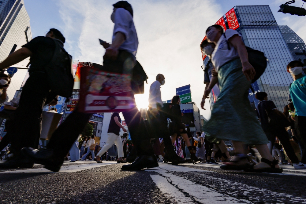Passersby wearing protective face masks walk on the Shibuya crossing, amid the coronavirus disease (COVID-19) pandemic, in Tokyo, Japan July 28, 2022. (REUTERS/Issei Kato)