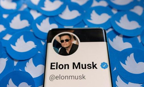 Elon Musk's Twitter profile is seen on a smartphone placed on printed Twitter logos in this picture illustration. REUTERS/Dado Ruvic/Illustration