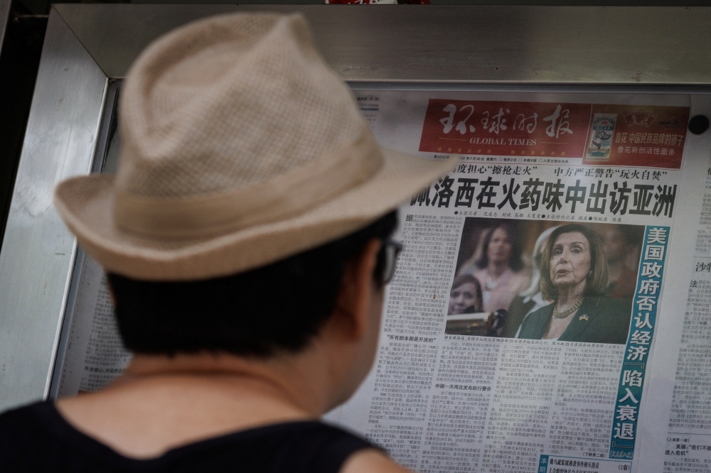 A man reads the Global Times newspaper that features a front page article about US House of Representatives Speaker Nancy Pelosi's Asia tour at a street display wall in Beijing, China, August 1, 2022. The front page headline reads: 