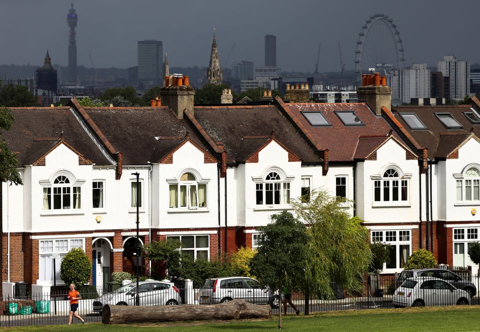 A person jogs past a row of residential housing in south London, Britain, August 6, 2021. REUTERS/Henry Nicholls

L