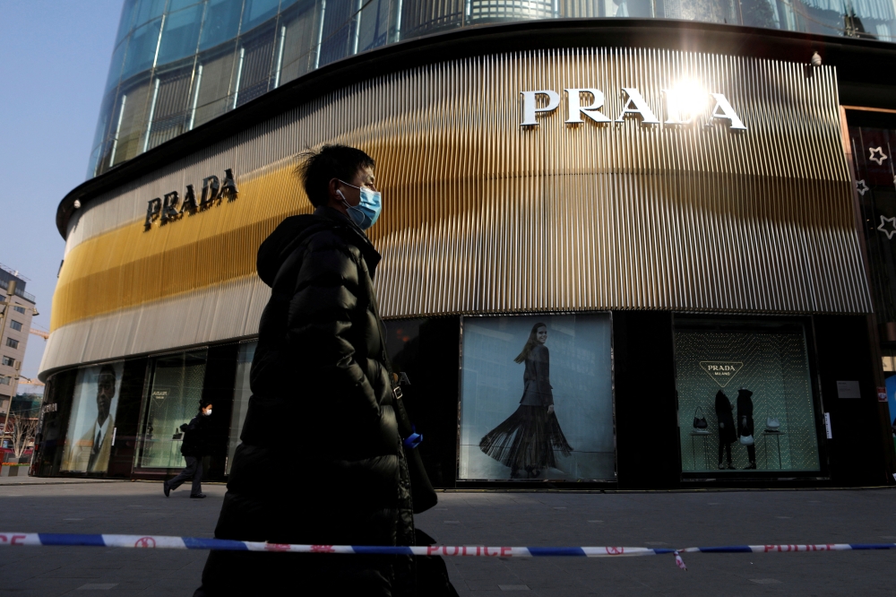 File Photo: A man walks past a store of Italian luxury brand Prada on a shopping street in Beijing, China, January 20, 2021. (REUTERS/Tingshu Wang)