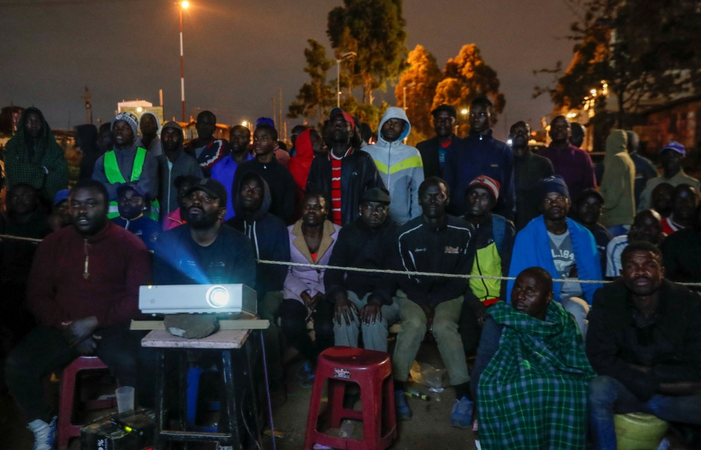People use a projector to follow the counting of the casted votes in the general election in Kibera slums of Nairobi, Kenya August 10, 2022. Reuters/Thomas Mukoya