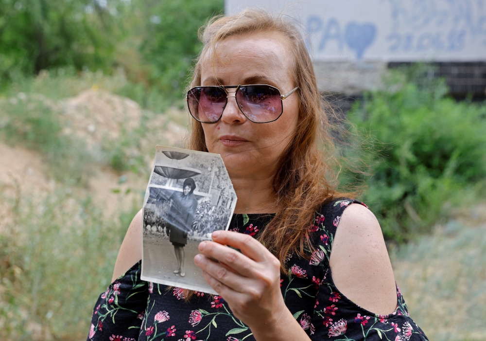 Lilia Ai-Talatini, 48, holds a picture of her mother, Ekaterina Yatsyuk in the Luhansk region, Ukraine August 12, 2022. Reuters/Alexander Ermochenko