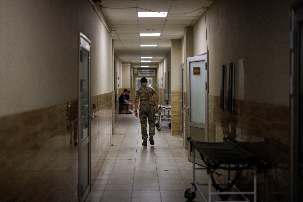A soldier, who assists at the emergency ward, makes his way in the corridor of a military hospital, as Russia's attack on Ukraine continues, in Donetsk region, Ukraine, August 9, 2022. REUTERS/Alkis Konstantinidis