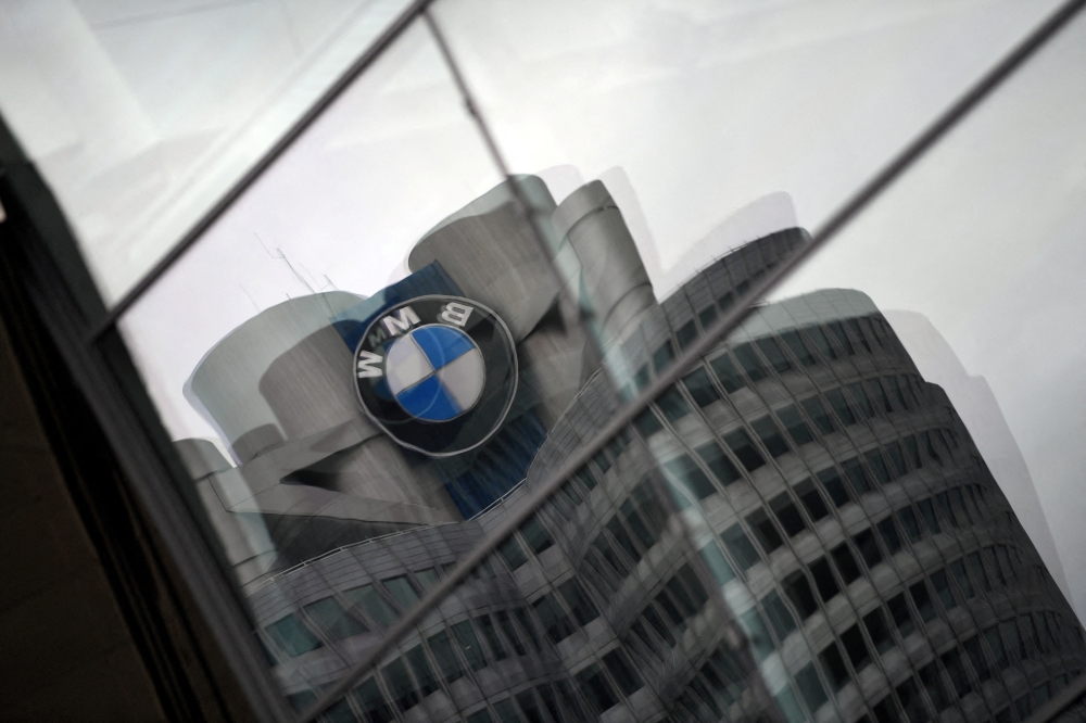 The logo of German car manufacturer BMW is reflected in a window at the company headquarters in Munich, Germany, May 14, 2020. REUTERS/Andreas Gebert/File Photo