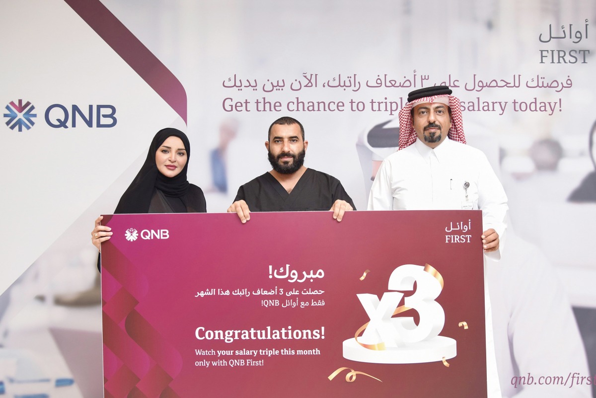 QNB officials awarding a winner of ‘Triple Your Salary’ campaign, in Doha, recently. 