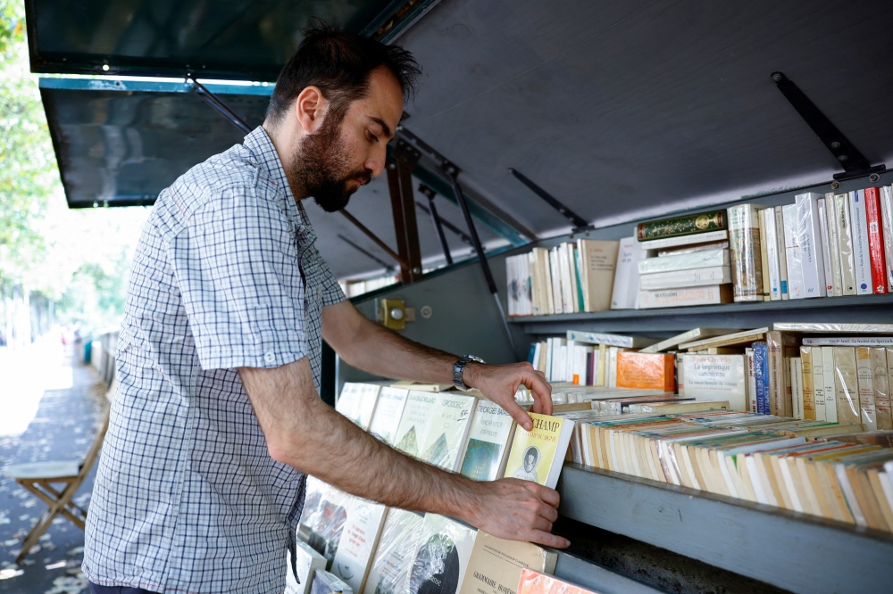 New Parisian bouquiniste, traditional street bookseller, Rachid Bouanou puts up stalls along the banks of the River Seine in Paris, France, August 18, 2022. REUTERS/Sarah Meyssonnier