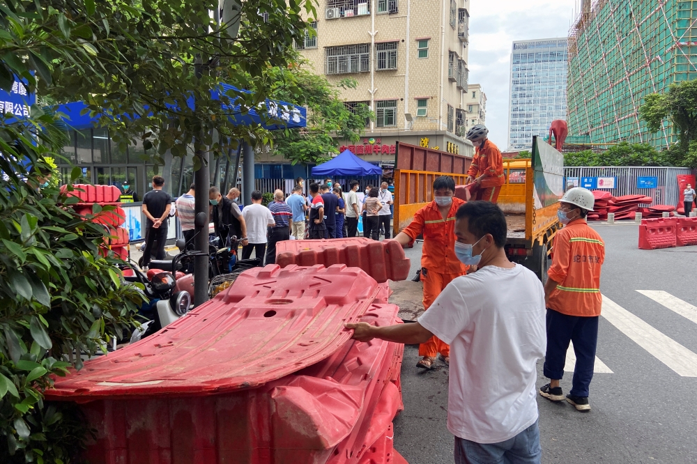 Workers set up barricades outside an entrance to Wanxia urban village as part of coronavirus disease (COVID-19) control measures in Shenzhen, Guangdong province, China August 29, 2022. REUTERS/David Kirton