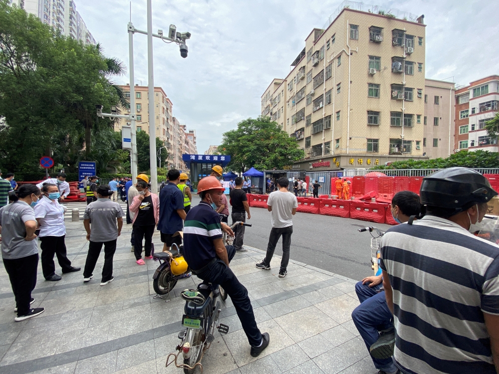 People watch as barricades are set up outside an entrance to Wanxia urban village as part of coronavirus disease (COVID-19) control measures in Shenzhen, Guangdong province, China August 29, 2022. REUTERS/David Kirton