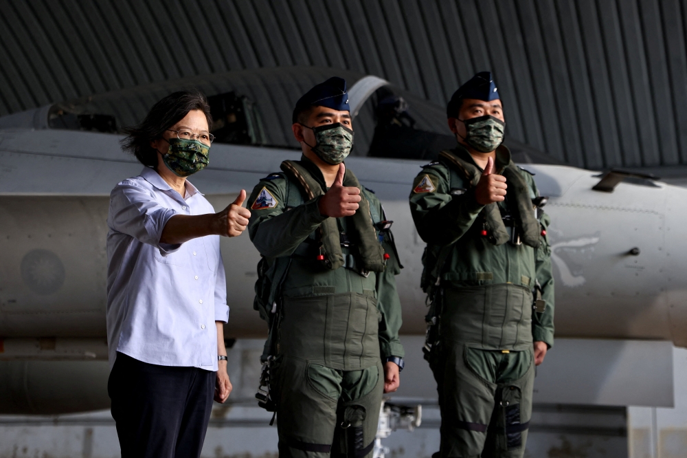 Taiwan President Tsai Ing-wen poses for a photo with pilots at an Air Force base in Penghu Islands, Taiwan, August 30, 2022. (REUTERS/Ann Wang)