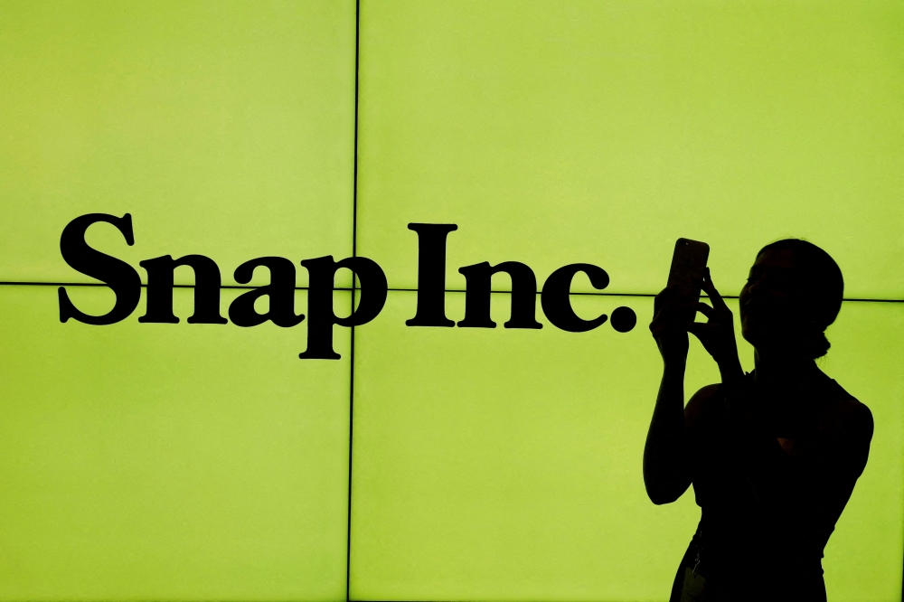 A woman stands in front of the logo of Snap Inc. on the floor of the New York Stock Exchange (NYSE) in New York City, on March 2, 2017. File Photo / Reuters