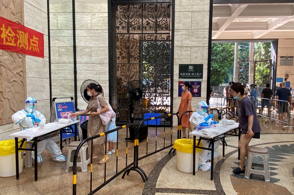 Medical workers in protective suits collect swabs from residents at a residential compound in Nanshan district, following a coronavirus disease (COVID-19) outbreak in Shenzhen, Guangdong province, China, on September 3, 2022. REUTERS/David Kirton