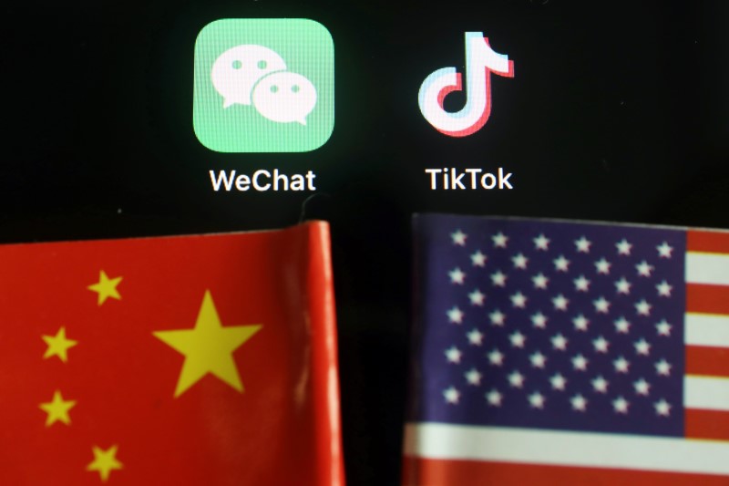 The messenger app WeChat and short-video app TikTok are seen near China and U.S. flags in this illustration picture taken on August 7, 2020. REUTERS/Florence Lo/Illustration