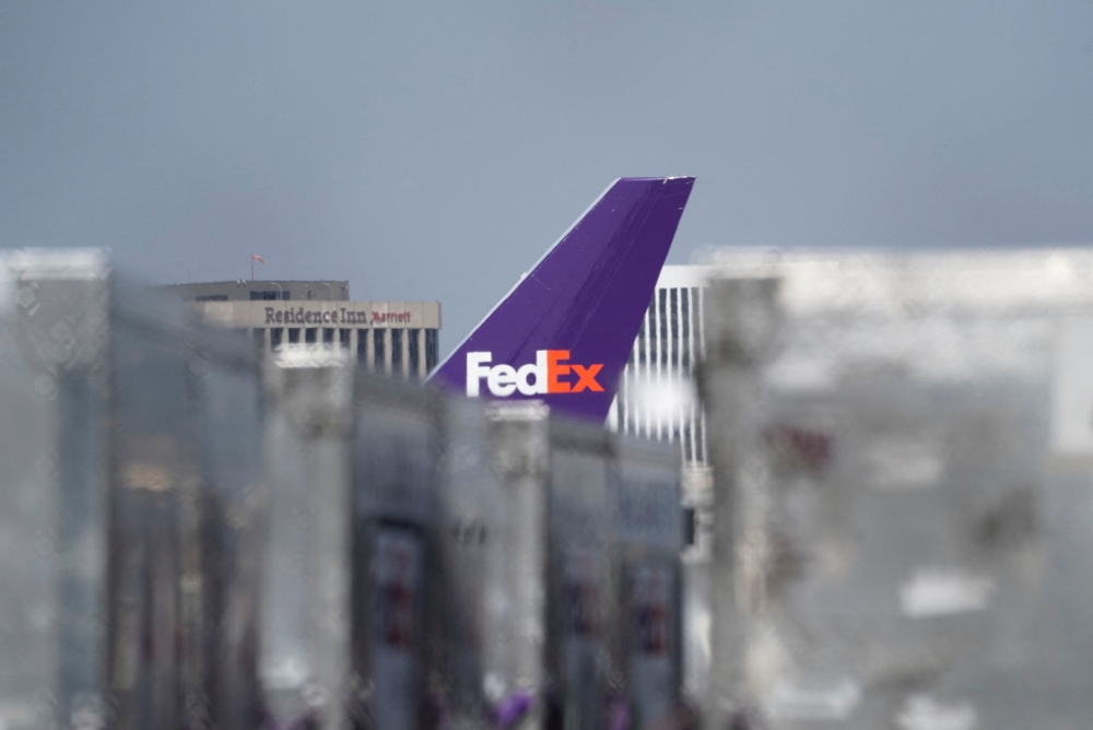 The tail fin of a cargo aircraft with FedEx livery is seen among air freight containers at a FedEx regional hub at Los Angeles International Airport (LAX) in Los Angeles, California, US, on September 16, 2022. (REUTERS/Bing Guan)