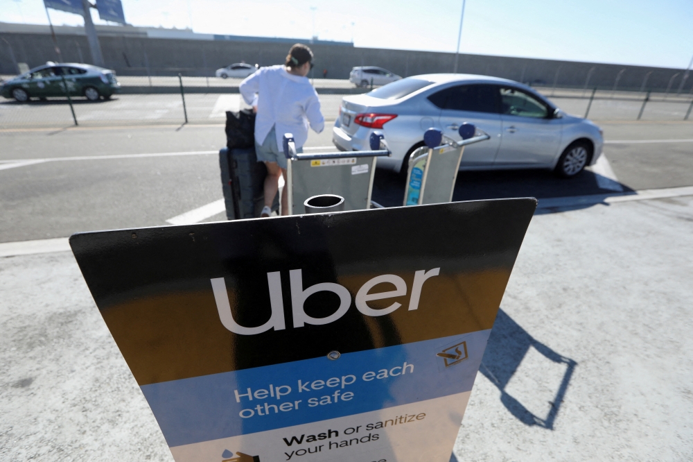 Uber signage is posted at Los Angeles International Airport (LAX) in Los Angeles, California, on July 10, 2022. REUTERS/David Swanson/File Photo