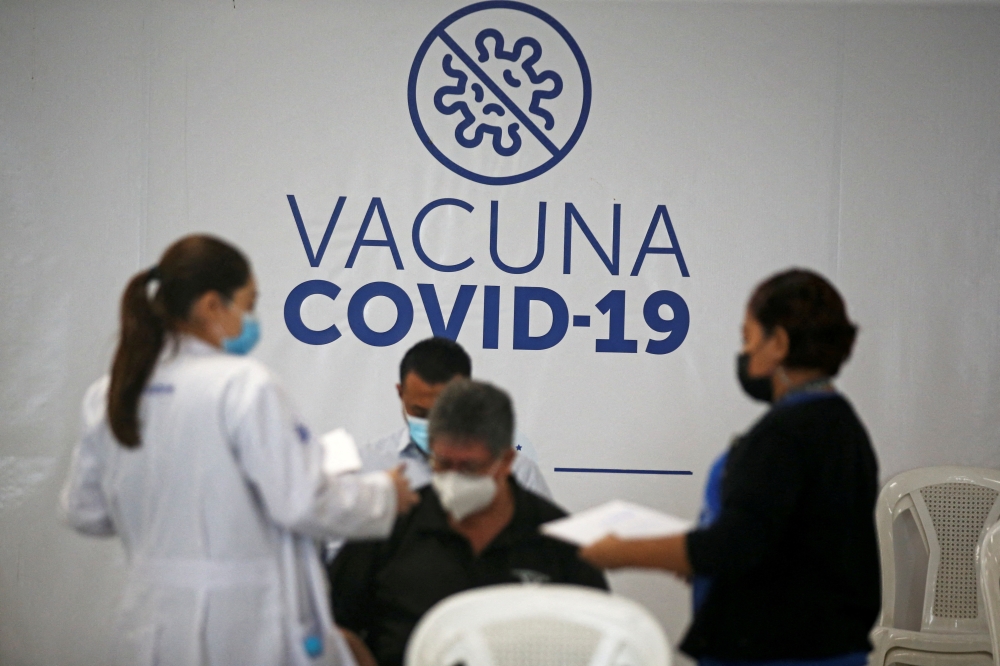 People wait in an observation room after receiving a dose of Pfizer-BioNTech coronavirus disease (Covid-19) vaccine at a vaccination center in San Salvador, El Salvador, on March 22, 2022. (REUTERS/Jose Cabezas)