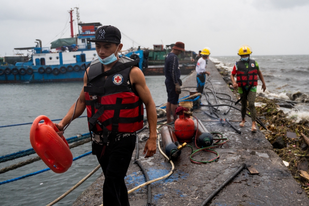Volunteers and local officials patrol the neighbourhood to remind residents to evacuate, in preparation for Super Typhoon Noru, in Manila, Philippines, September 25, 2022. REUTERS/Lisa Marie David