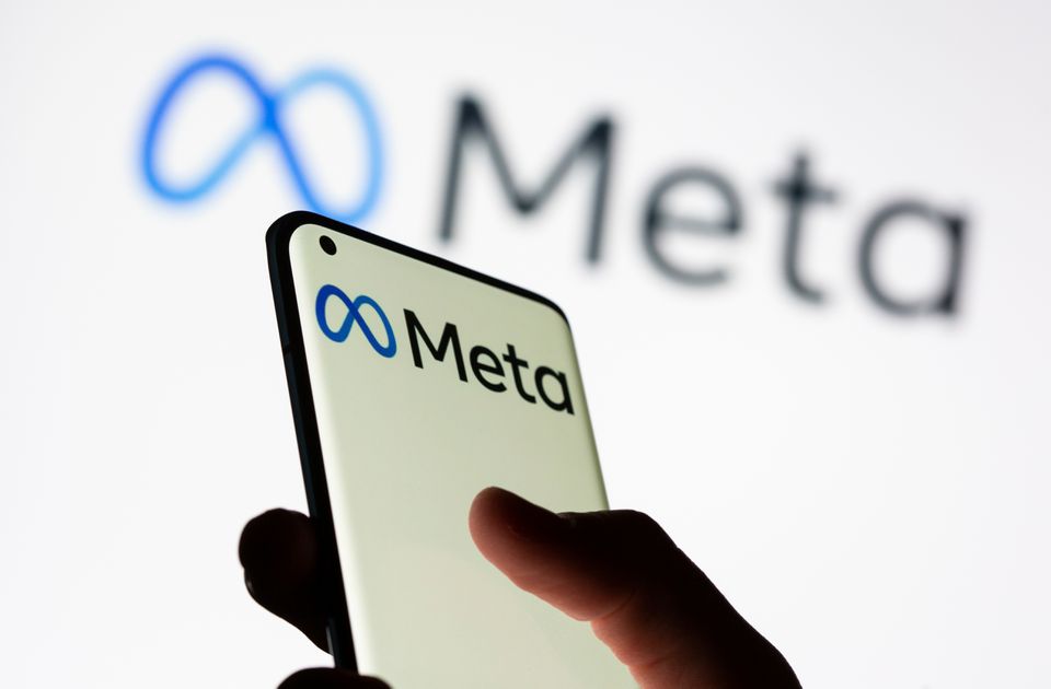 Woman holds smartphone with Meta logo in front of a displayed Facebook's new rebrand logo Meta in this illustration picture taken on October 28, 2021. File Photo / Reuters
