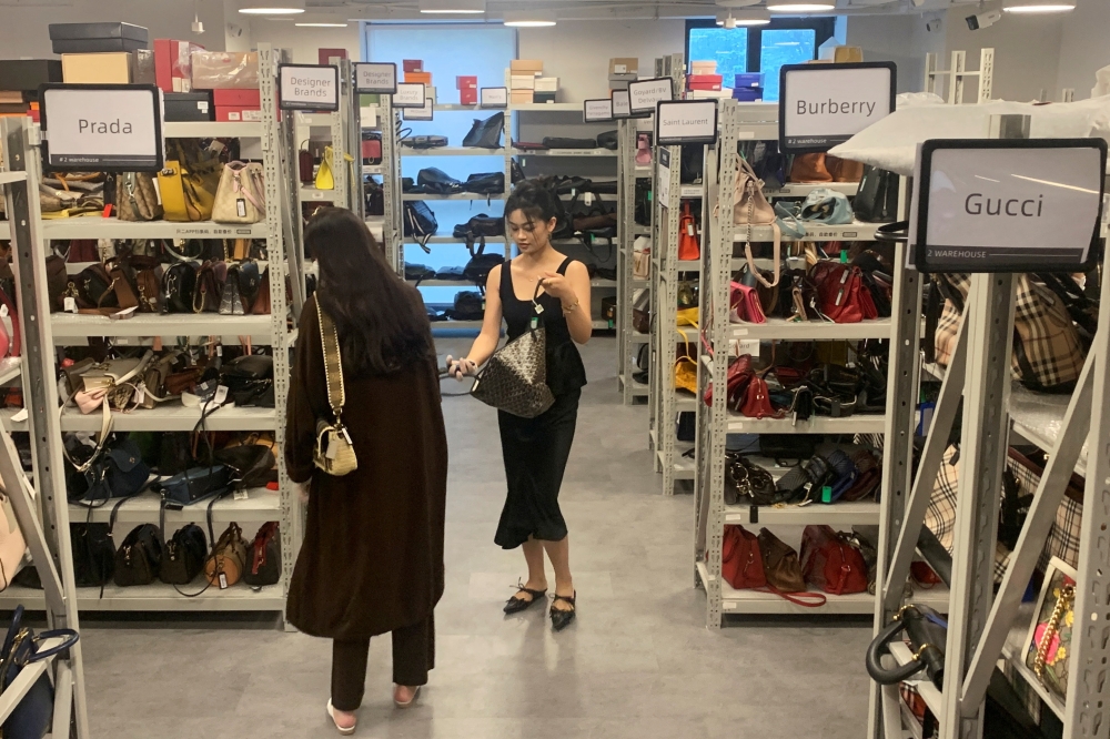 Customers look at bags displayed at a store of second-hand luxury goods platform ZZER in Shanghai, China September 9, 2022. Reuters/Xihao Jiang