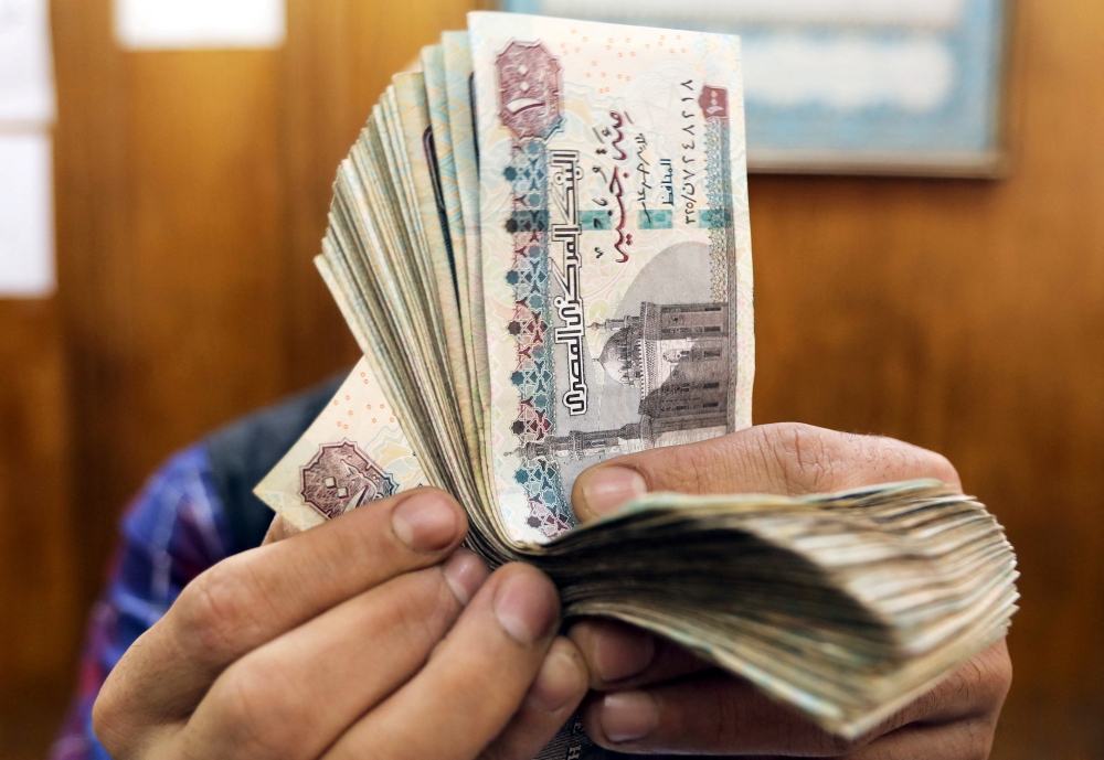 An employee counts Egyptian pounds at a foreign exchange office in central Cairo, Egypt, on March 20, 2019. File Photo / Reuters
