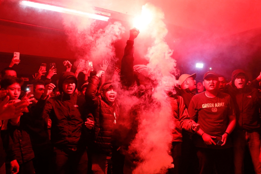 Football club supporters light a red flare during a vigil at Patriot Candrabhaga Stadium, after a riot and stampede at Kanjuruhan Stadium following a soccer match between Arema vs Persebaya Surabaya, in Bekasi, on the outskirts of Jakarta, Indonesia, on October 3, 2022. (REUTERS/Ajeng Dinar Ulfiana)