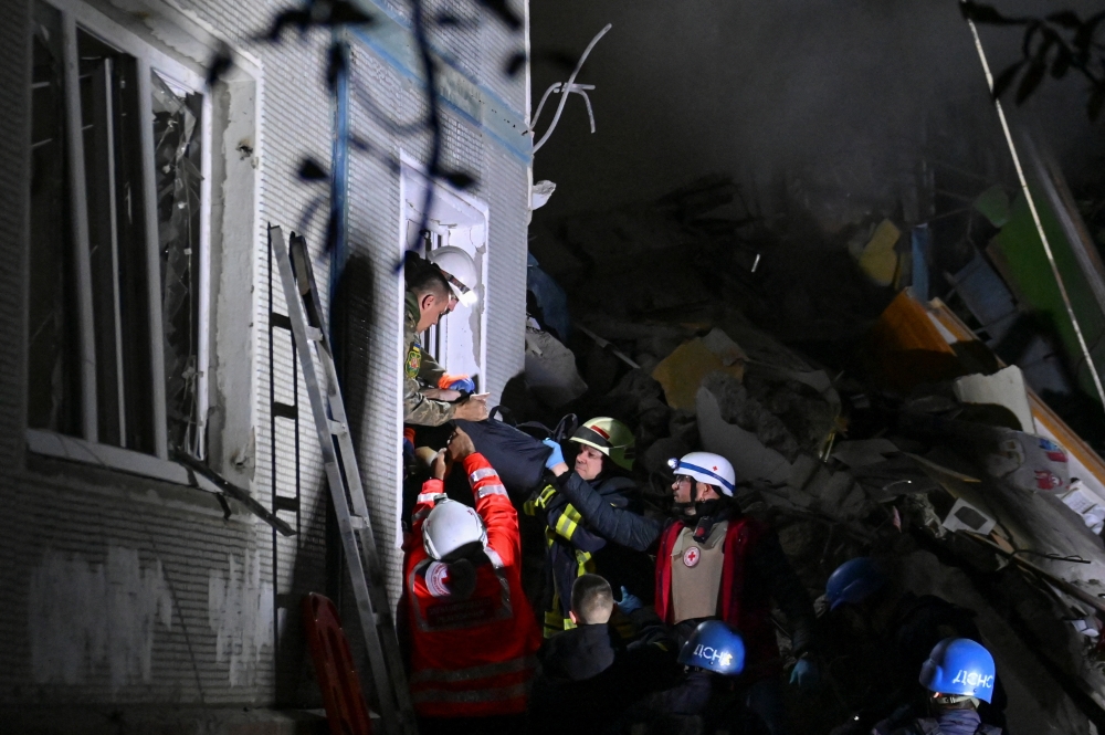 Rescuers carry a person out of a residential building heavily damaged by a Russian missile strike, amid Russia's attack on Ukraine, in Zaporizhzhia, Ukraine October 9, 2022. Reuters/Stringer