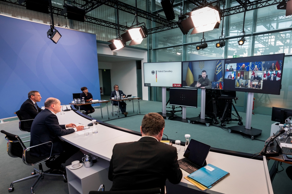 Ukrainian President Volodymyr Zelenskiy appears on a screen during a virtual G7 leaders meeting at the Chancellery in Berlin, Germany, on October 11, 2022. (Steffen Kugler/BPA/Handout via REUTERS)