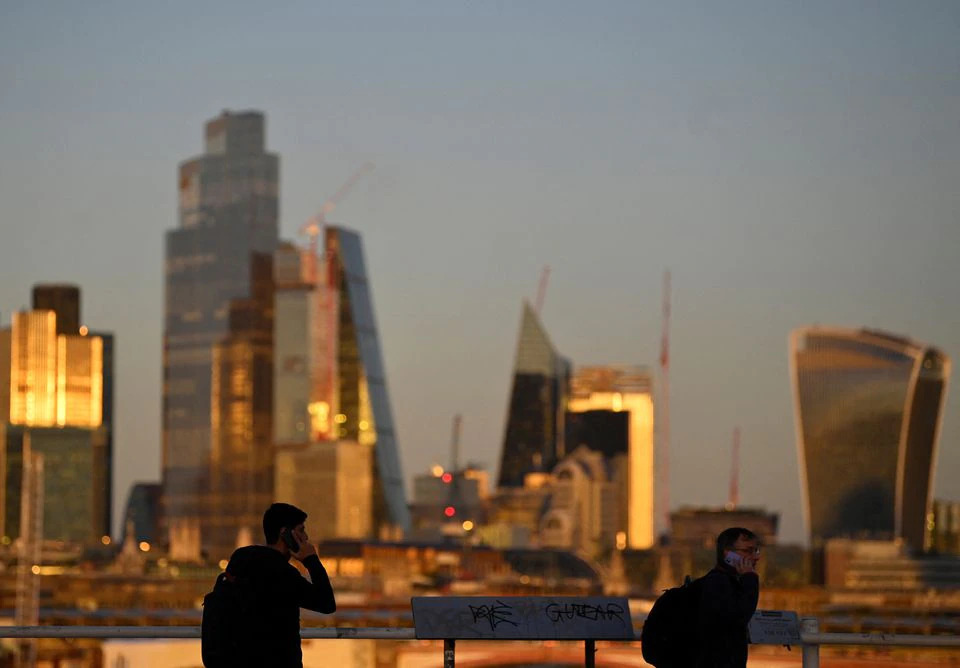 People cross Waterloo Bridge during the evening rush-hour with skyscrapers of the City of London financial district seen behind in London, Britain, on October 10, 2022. REUTERS/Toby Melville
