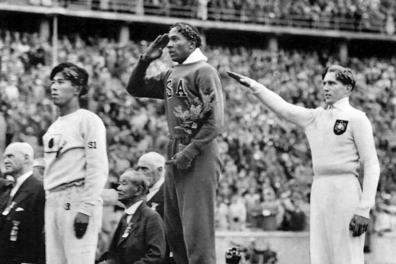 Photo credit: On August 11, 1936, America's Jesse Owens salutes during the presentation of his gold medal for the long jump, alongside silver medalist Luz Long (right) of Germany, and bronze medalist Naoto Tajima of Japan during the 1936 Summer Olympics in Berlin. (AP Photo/File)