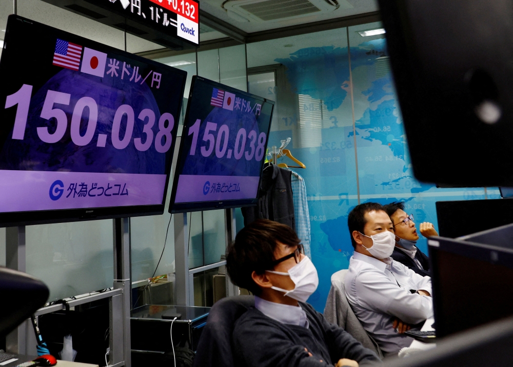 Employees of the foreign exchange trading company Gaitame.com react as they watch the Japanese yen exchange rate against the U.S. dollar at its dealing room in Tokyo