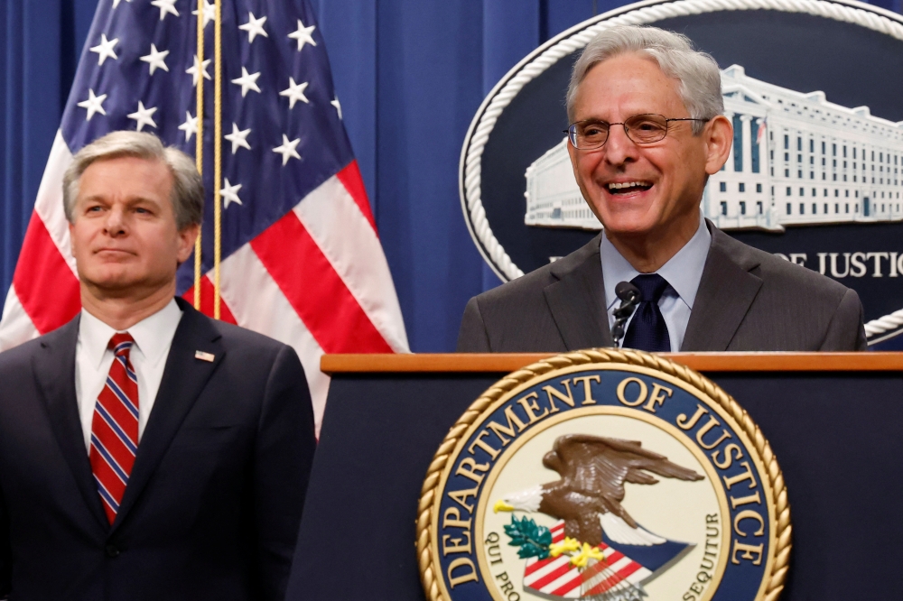 US Attorney General Merrick Garland, with Federal Bureau of Investigation (FBI) Director Christopher Wray, reacts to a reporter's question after announcing charges against two Chinese nationals for trying to obstruct the prosecution of China's Huawei Technologies Co Ltd, and four others with trying to spy for Beijing, at the Justice Department in Washington on October 24, 2022. REUTERS/Jonathan Ernst