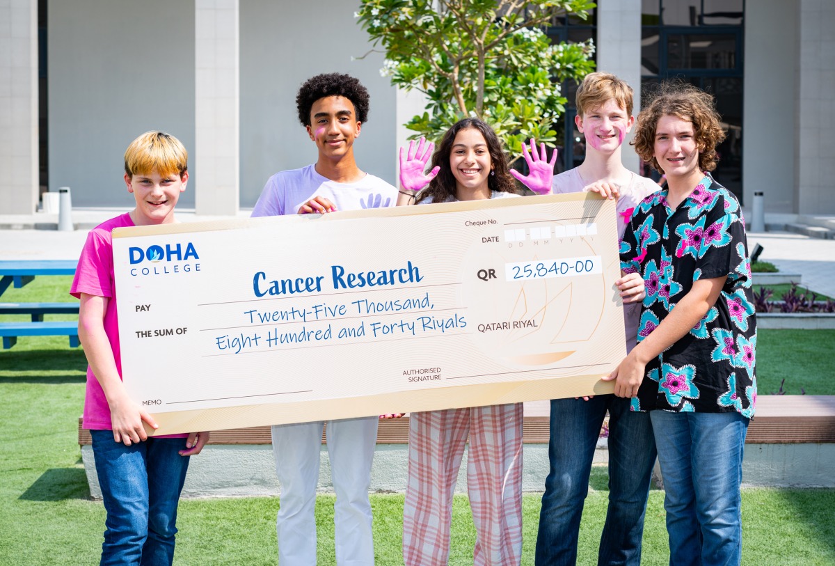 Doha College students with a cheque of QR25,840. 