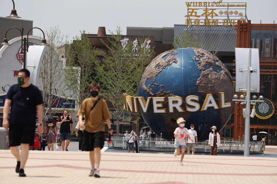 Tourists walk near an entrance to the Universal Studios theme park as it reopens to the general public, following the coronavirus disease (COVID-19) outbreak in Beijing, China June 25, 2022. REUTERS/Tingshu Wang/File Photo
