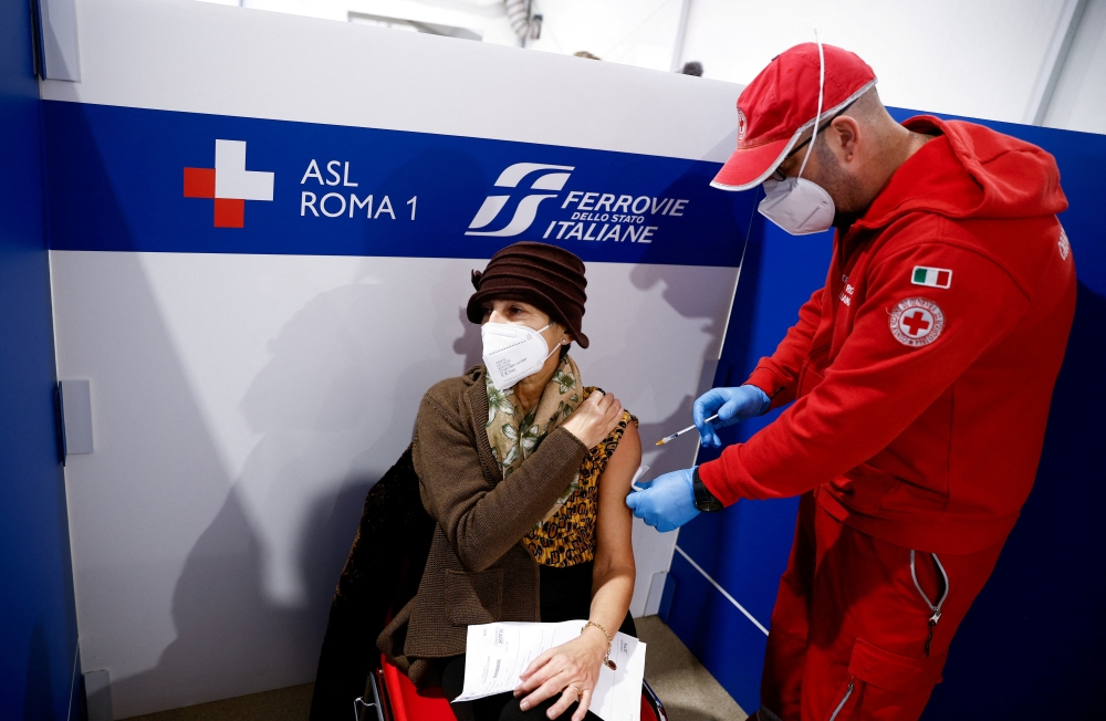 A woman receives a dose of the vaccine against the coronavirus disease (COVID-19), on the day Italy brings in tougher rules for the unvaccinated, at a Red Cross vaccination centre by Termini main train station in Rome, Italy, January 10, 2022. REUTERS/Guglielmo Mangiapane/File Photo