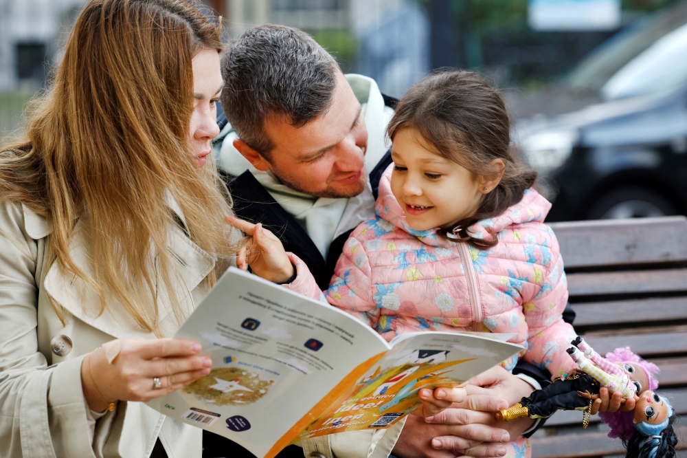 Ukrainian family Mykhalchenko read and listen to Better Time Stories, a project introduced for Ukrainian children who are seperated from their families in Rotterdam, Netherlands October 25, 2022. REUTERS/Piroschka van de Wouw