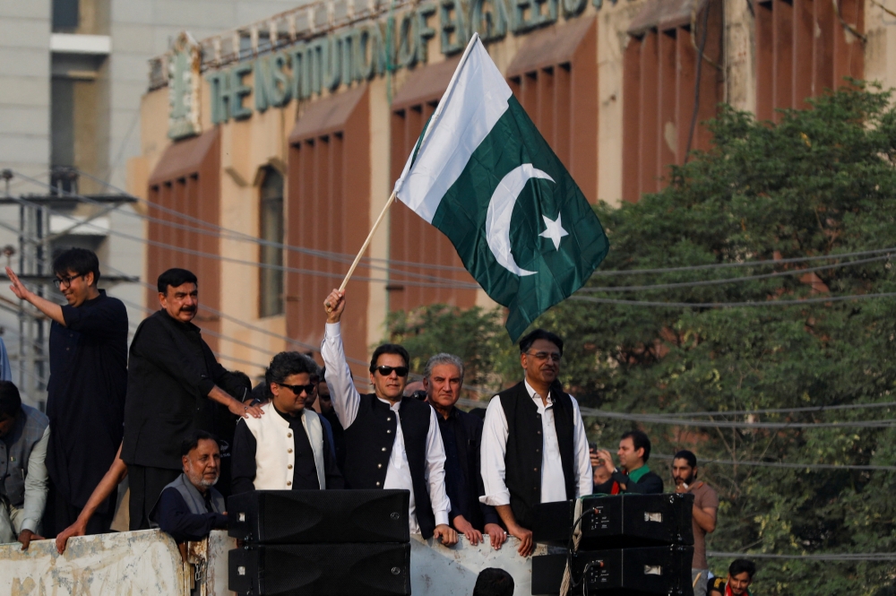 Pakistan's former prime minister Imran Khan waves the national flag during what they call 'a true freedom march', to pressure the government to announce new elections, in Lahore, Pakistan, October 28, 2022. (REUTERS/Akhtar Soomro)