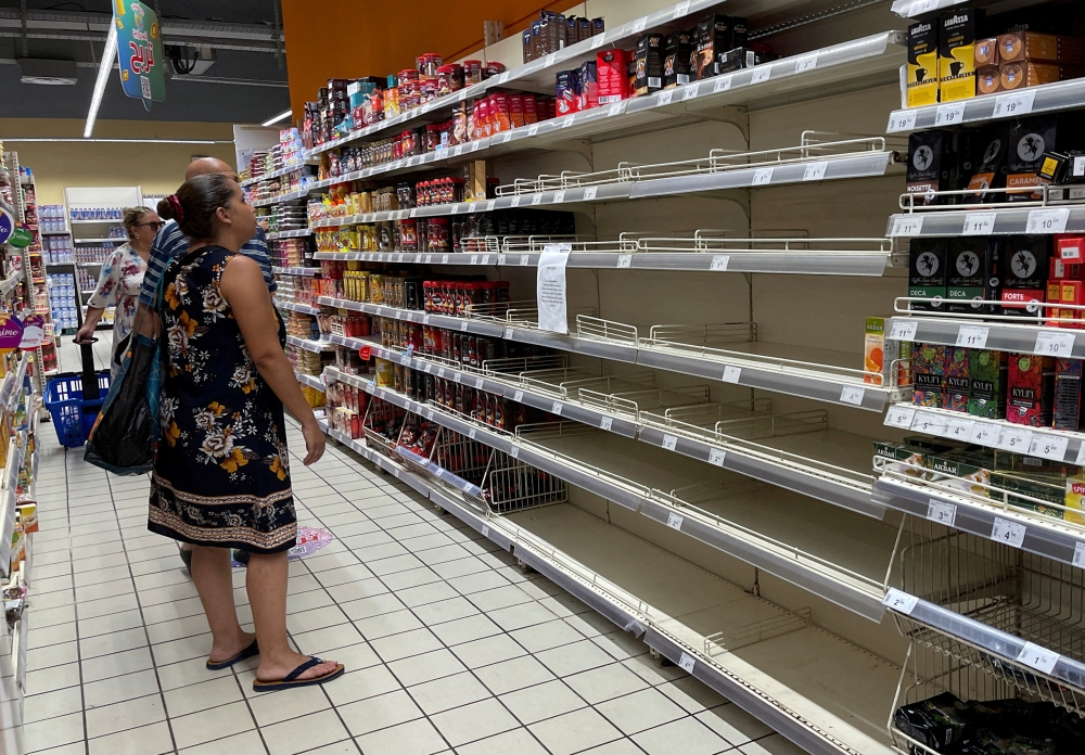 A customer stands in front of empty shelves for some coffee products inside a supermarket in Tunis, Tunisia, on September 3, 2022.  File Photo / Reuters
