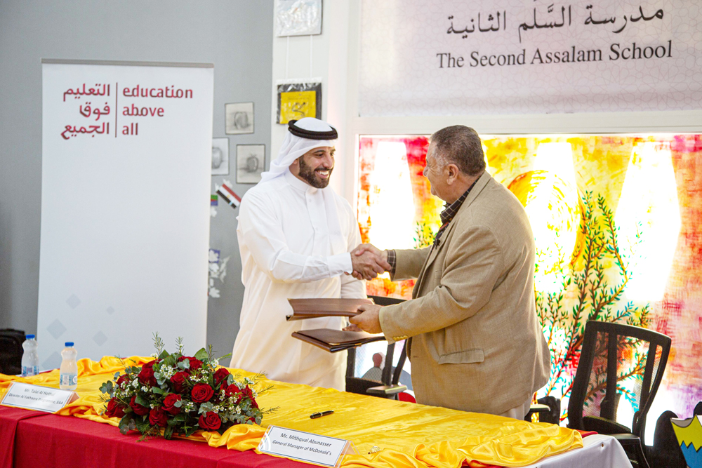 McDonald’s Qatar and Education Above All officials exchange the agreement.
