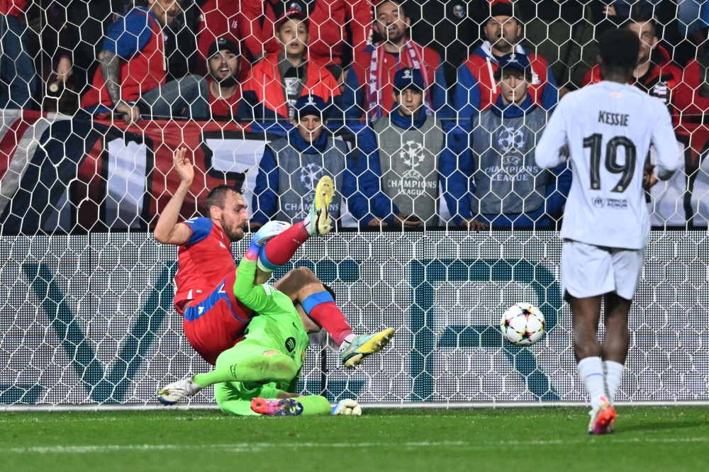 Viktoria Plzen's Czech forward Tomas Chory (top L) falls over Barcelona's Spanish goalkeeper Inaki Pena during the UEFA Champions League Group C football match FC Viktoria Plzen v FC Barcelona in Plzen, Czech Republic, on November 1, 2022.  Joe Klamar / AFP
