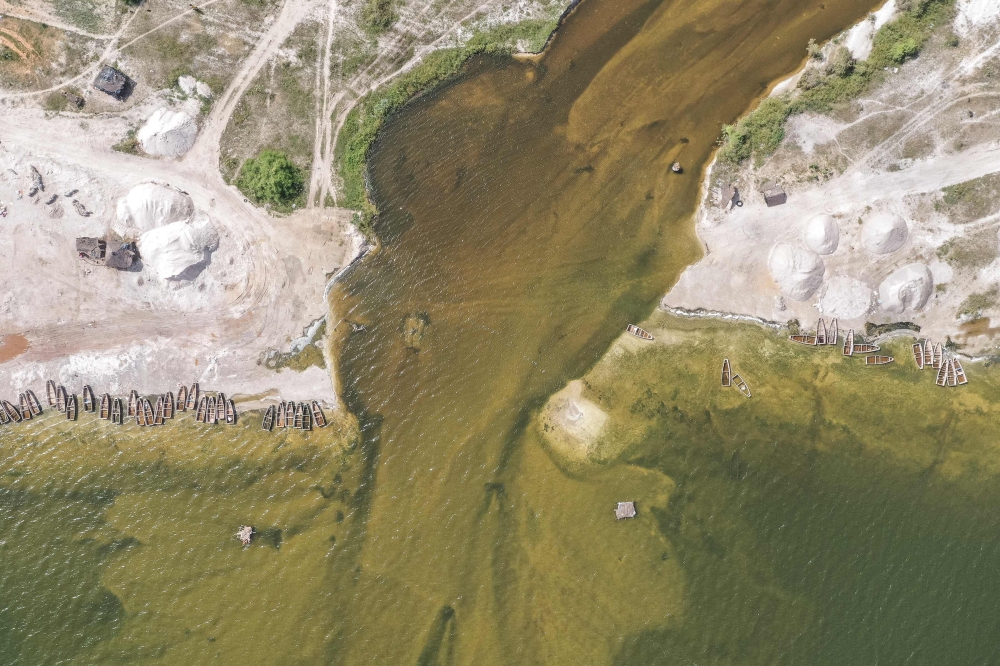 This aerial view shows the breach where flood waters broke through and water from the surrounding flooded towns is pumped into Lake Rose (also known as Lake Retba) in Niaga on October 19, 2022. (Photo by JOHN WESSELS / AFP)