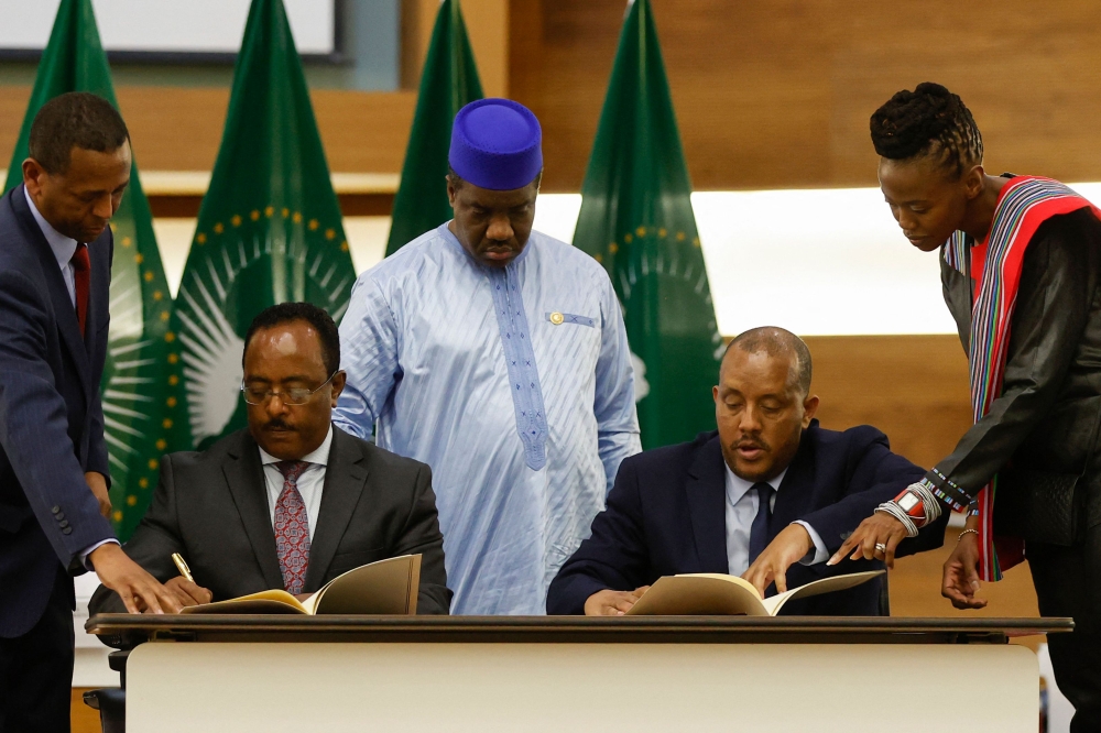 Redwan Hussien Rameto (second left), Representative of the Ethiopian government, and Getachew Reda (second rigth), Representative of the Tigray People's Liberation Front (TPLF), sign a peace agreement between the two parties during a press conference regarding the African Union-led negotiations to resolve conflict in Ethiopia at the Department of International Relations and Cooperation (DIRCO) offices in Pretoria on November 2, 2022. (Photo by PHILL MAGAKOE / AFP)