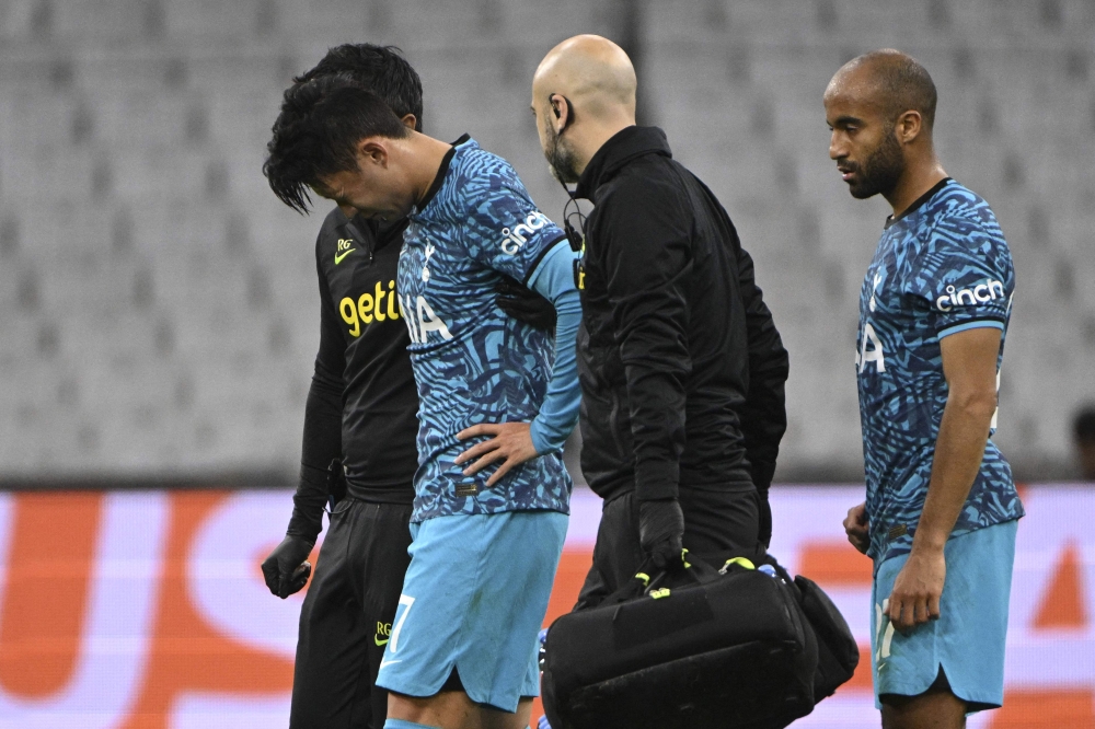Tottenham's South Korean striker Son Heung-Min (2nd-L) leaves the pitch after sustaining an injury as Tottenham's Brazilian midfielder Lucas Moura (R) follows him during the UEFA Champions League group D football match between Olympique Marseille (OM) and Tottenham Hotspur at The Velodrome Stadium in Marseille, southern France on November 1, 2022. (Photo by Christophe SIMON / AFP)
