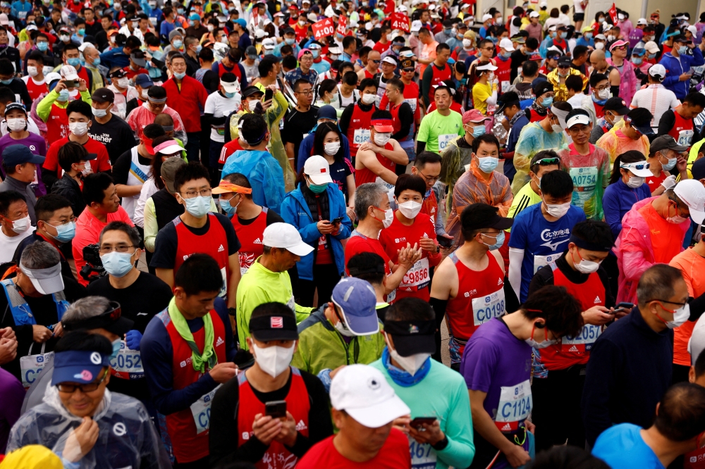 Participants wait before the start of the Beijing Marathon, the first in two years after being canceled in 2020 and 2021 because of the coronavirus disease (COVID-19), in Beijing, China November 6, 2022. REUTERS/Tingshu Wang